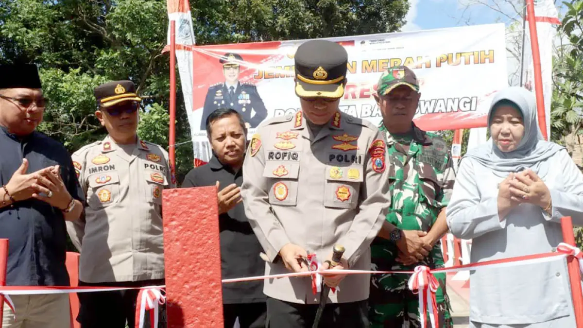 Kapolresta Kombespol Rofiq Ripto Himawan memotong pita sebagai simbol peresmian Jembatan Merah Putih Presisi di Dusun Krajan, Desa Watukebo, Kecamatan Blimbingsari, Minggu (31/5). (Humas Polresta Banyuwangi)