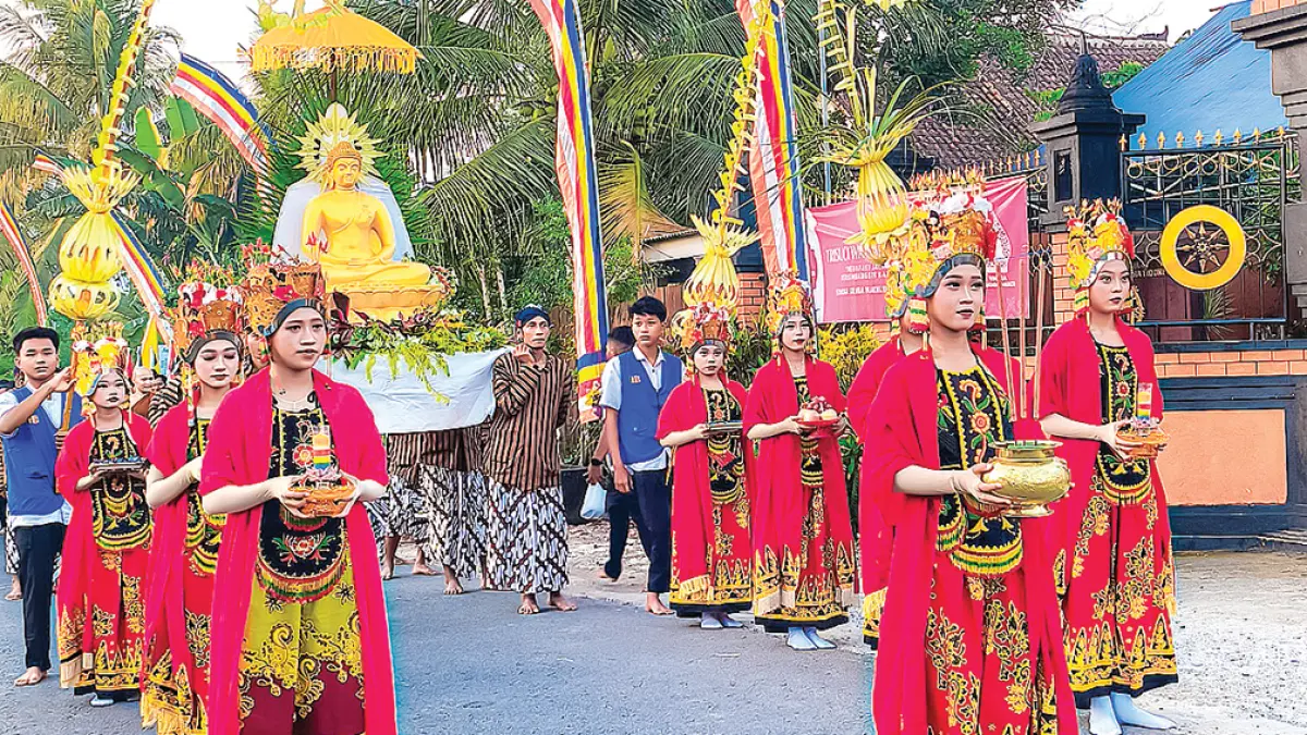 KELILING KAMPUNG: Umat Buddha Vihara Dhamma Mukti, Dusun Sidomukti, Desa Yosomulyo, Kecamatan Gambiran mengadakan kirab rupang diiringi gandrung pada Minggu sore (31/5). (Nanang for Radar Banyuwangi)
