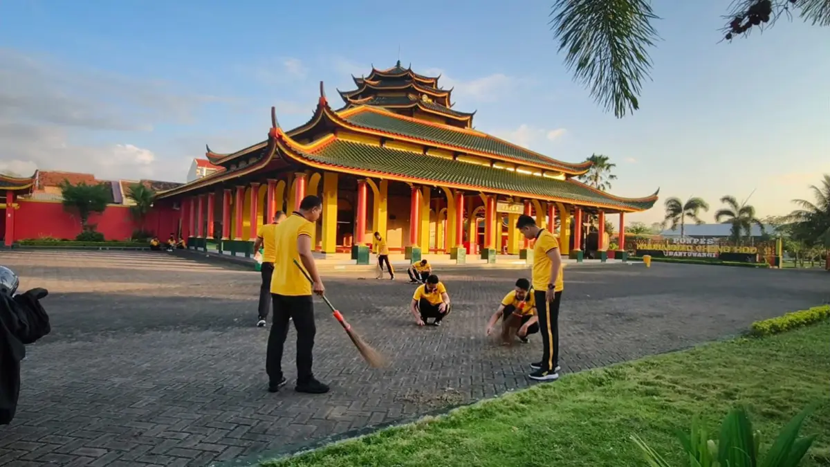 AKSI SOSIAL: Personel Polresta Banyuwangi menyapu halaman Masjid Ceng Hoo dalam rangkaian peringatan HUT ke-80 Bhayangkara, Jumat (5/6). (Humas Polresta Banyuwangi)