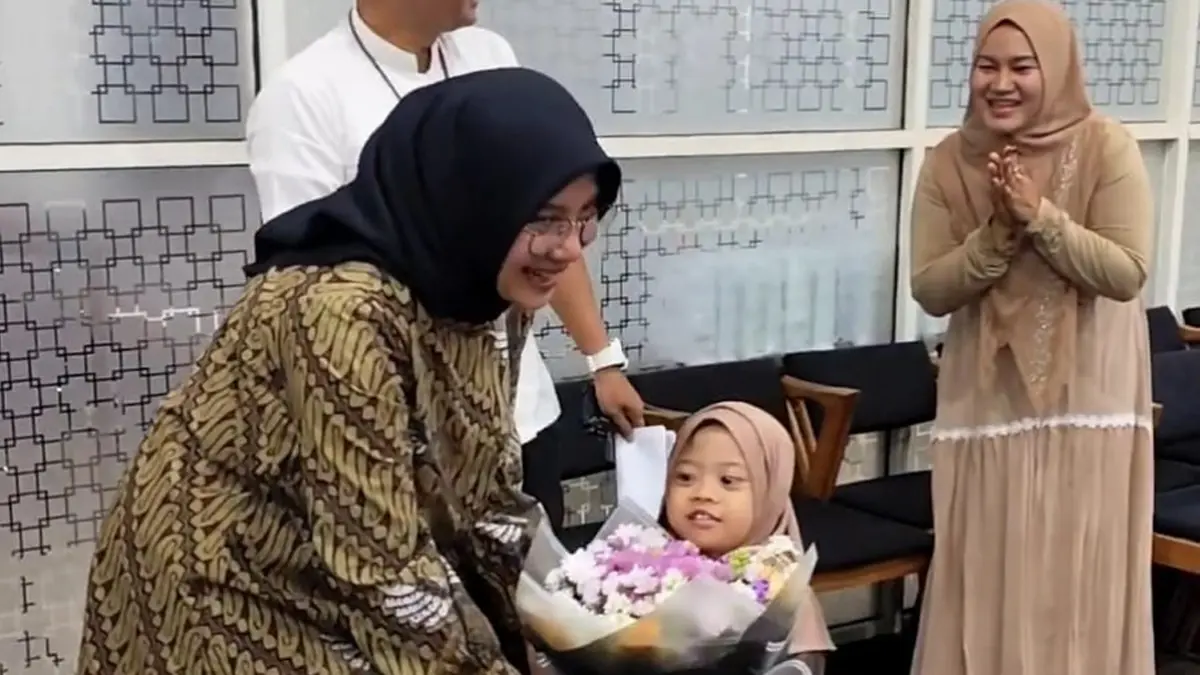 Bupati Ipuk Fiestiandani menerima buket bunga dari bocah perempuan saat menghadiri lokakarya yang digelar Perkins International di Aula Café & Resto Bale Saji, Kecamatan Kabat, Selasa malam (2/6). (Humas Pemkab Banyuwangi)