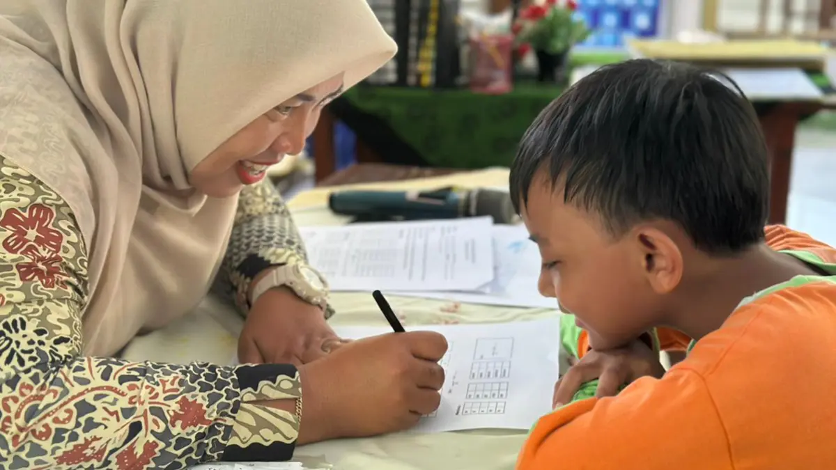 PANTAU BAKAT: Guru SDN 1 Karangrejo melakukan asesmen kepada salah satu calon siswa baru beberapa waktu lalu (21/5). (Fredy Rizki/Radar Banyuwangi)