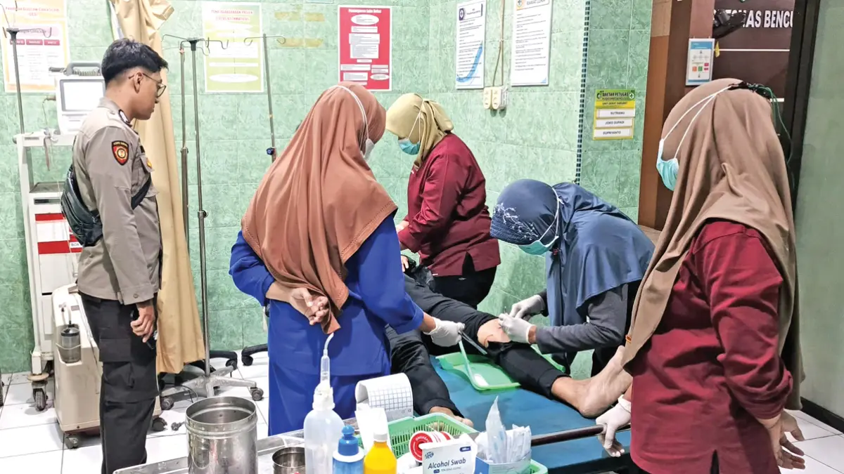LUKA-LUKA: Pengendara sepeda motor dilarikan ke Puskesmas Benculuk usai tabrak truk di Jalan Raya Desa Sraten, Kecamatan Cluring, Minggu dini hari (7/6). (Putu Ardana for Radar Banyuwangi)