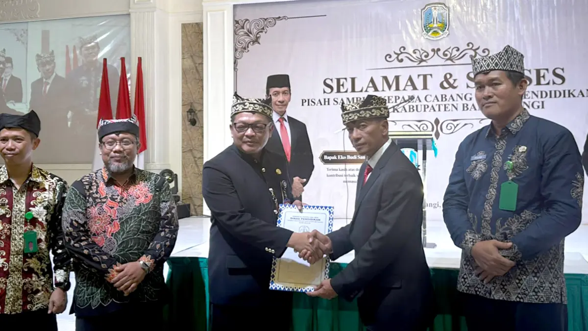 PIMPINAN BARU: Plt Kepala Cabang Dinas Pendidikan Banyuwangi Iwan Triyono menandatangani surat serah terima jabatan di Aula SMKN 1 Banyuwangi, Minggu (7/6). (Fredy Rizki/Radar Banyuwangi)