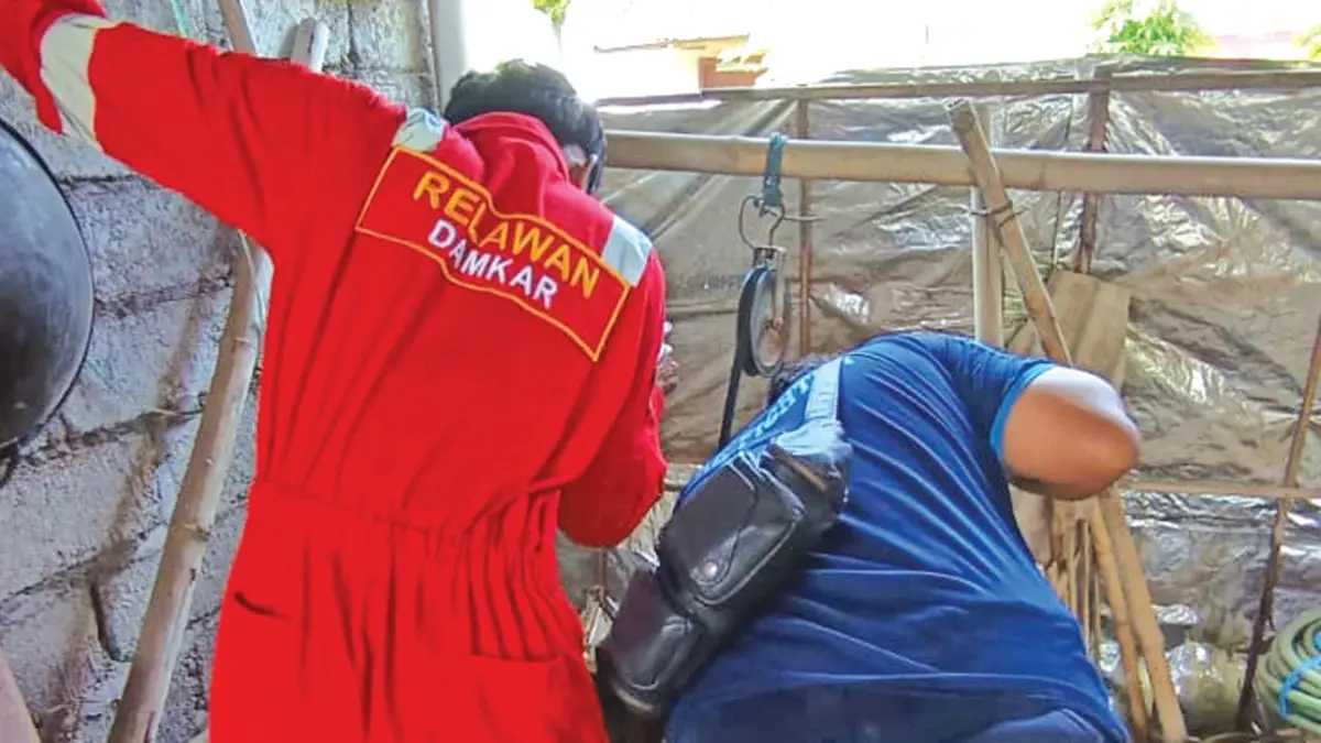 SELAMAT: Petugas Damkar Sektor Srono Evakuasi kucing masuk sumur di Desa Rejoagung, Kecamatan Srono pada beberapa hari lalu. (Heri Siswanto for Radar Banyuwangi)