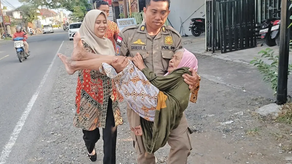 EVAKUASI: Petugas Satpol PP evakuasi nenek pikun di kawasan Desa Genteng Kulon, Kecamatan Genteng, Senin (8/6). (Masruri for Radar Banyuwangi)