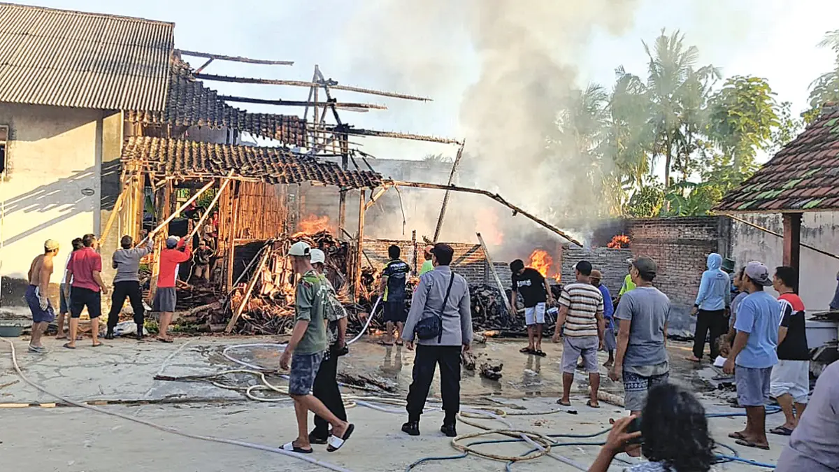 Warga bersama petugas Damkarmat gotong royong memadamkan api yang membakar gudang kayu di Desa Sidorejo, Kecamatan Purwoharjo, Minggu sore (7/6). (Agus Suhartono for Radar Banyuwangi)