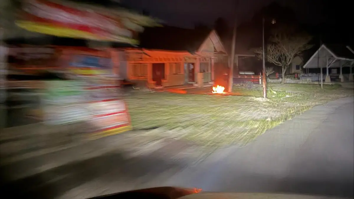 BLACK OUT: Gara-gara listrik padam, warga di daerah Kampunganyar, Glagah, membakar kayu di halaman rumahnya sebagai penerangan, petang, Rabu (10/6). (Syaifuddin M/Radar Banyuwangi)