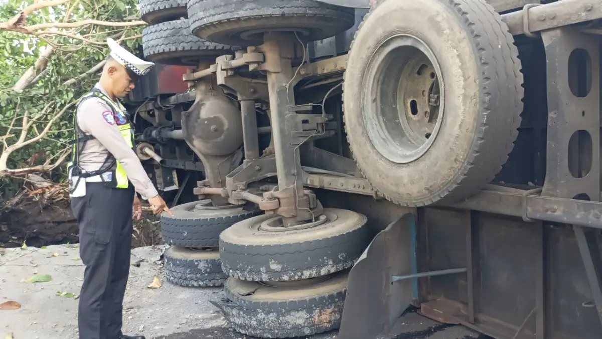 Petugas sedang memeriksa kondisi truk di TKP. (FOTO: Gerda/ Jawa Pos Radar Banyuwangi)