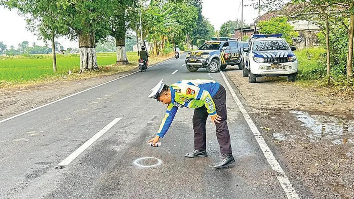 TANDAI LOKASI: Anggota Polresta Banyuwangi melakukan olah TKP kecelakaan lalu lintas di Dusun Krajan, Desa Parijatah Kulon, Kecamatan Srono, Jumat (12/6). (PEPRI for Radar Banyuwangi)