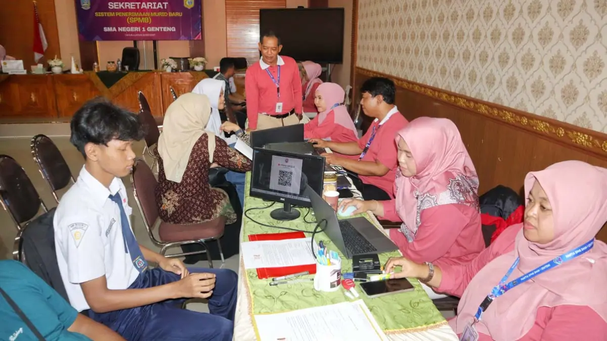 PENDAMPINGAN: Kepala SMAN 1 Genteng saat melakukan pendampingan daftar ulang calon peserta didik baru di sekolahnya, Sabtu (13/6). (Salis Ali/Radar Banyuwangi)