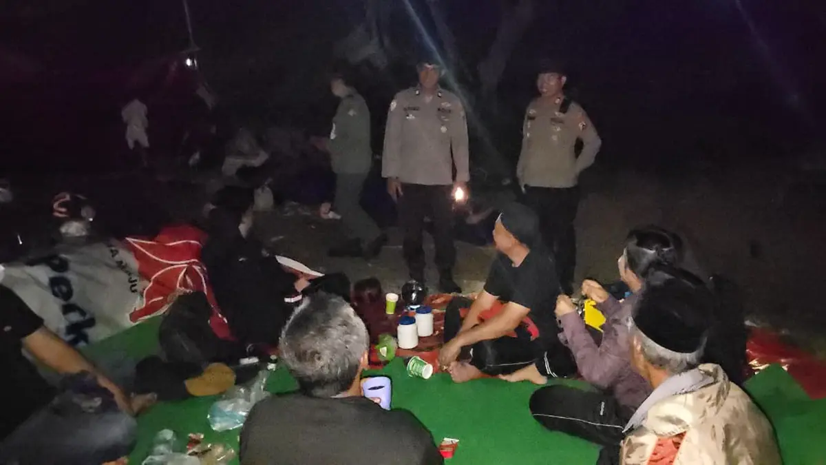 MEMANTAU: Anggota Polsek Tegaldlimo melakukan patroli pada tenda-tenda yang dipasang pengunjung di Alas Purwo pada Senin malam (15/6). (Sadimun for Radar Banyuwangi)