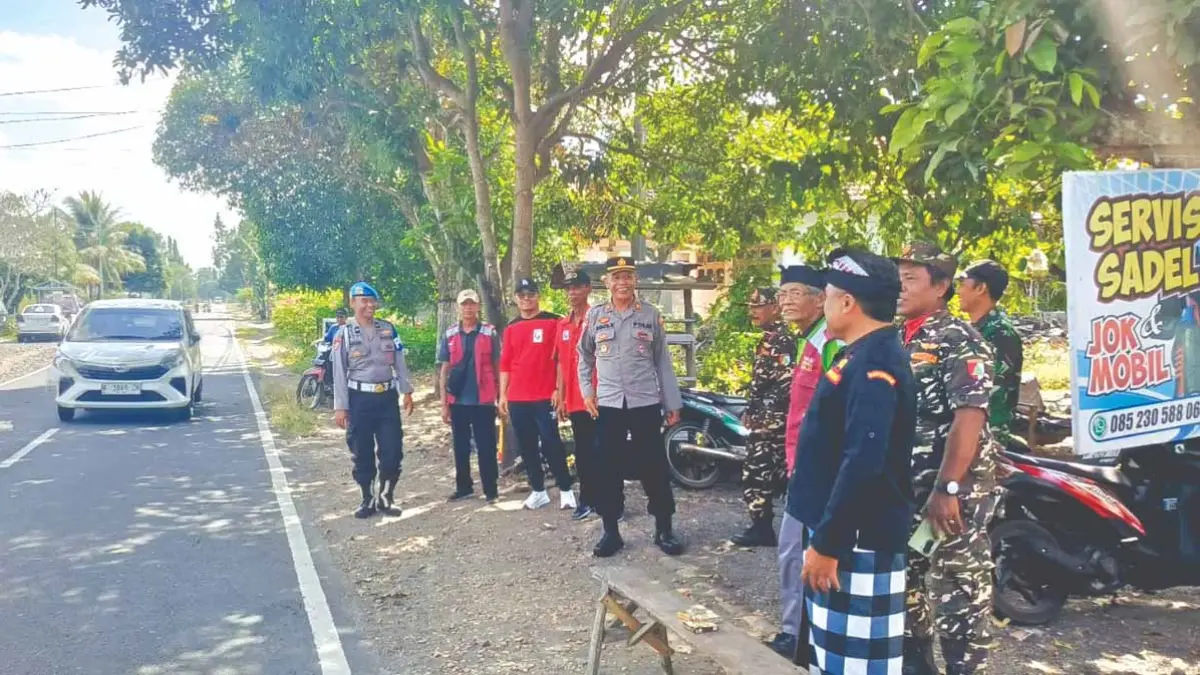 BERJAGA: Warga lintas agama bersama anggota Polsek Purwoharjo mengamankan pelaksanaan ibadah Galungan di Desa Karetan, Kecamatan Purwoharjo, Rabu (17/6). (Agus for Radar Banyuwangi)