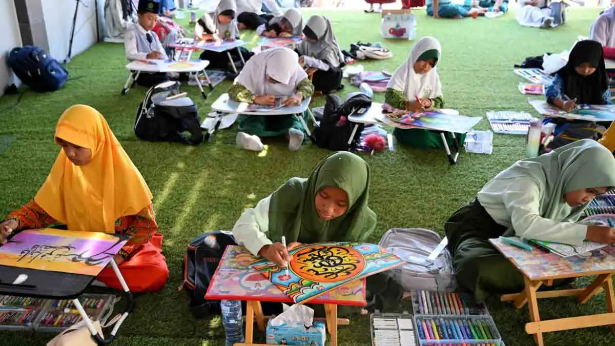 Peserta lomba mengerjakan kaligrafi. Aspek yang dinilai antara lain ketepatan penulisan sesuai kaidah kaligrafi, kreativitas, dan komposisi karya. (Ramada Kusuma/Radar Banyuwangi)