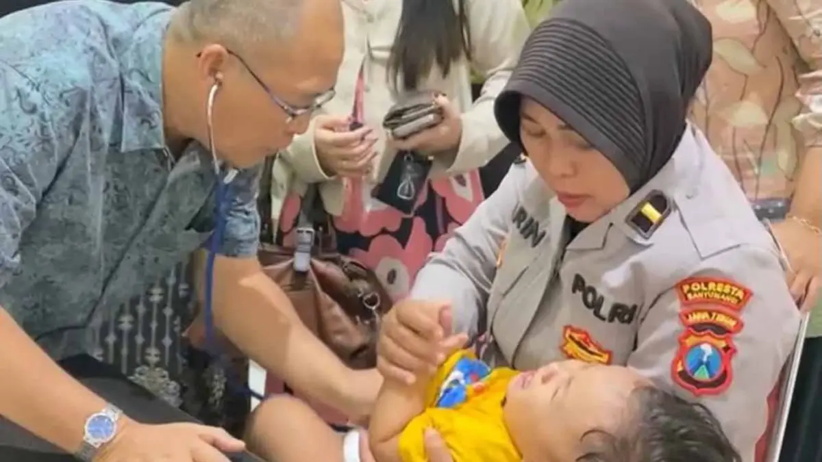 Petugas bersama Kepala Seksi Dokkes Polresta Banyuwangi Ipda Ririn Nurpiah melakukan pemeriksaan kesehatan salah satu anak peserta kegiatan pemeriksaan kesehatan gratis di Klinik Dokkes Polresta Banyuwangi. (Bagus Rio/Radar Banyuwangi)