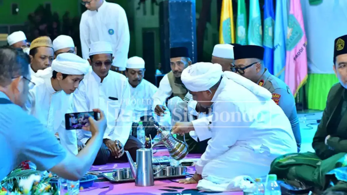 Habib Muhammad Taufiq Al Djufri menuangkan susu ke dalam cangkir untuk diminum bersama para santrinya pada malam pergantian Tahun Baru Islam di Pondok Pesantren Nurul Huda, Desa Peleyan, Kecamatan Kapongan, Senin (15/6) malam. (Ahmad Rifa