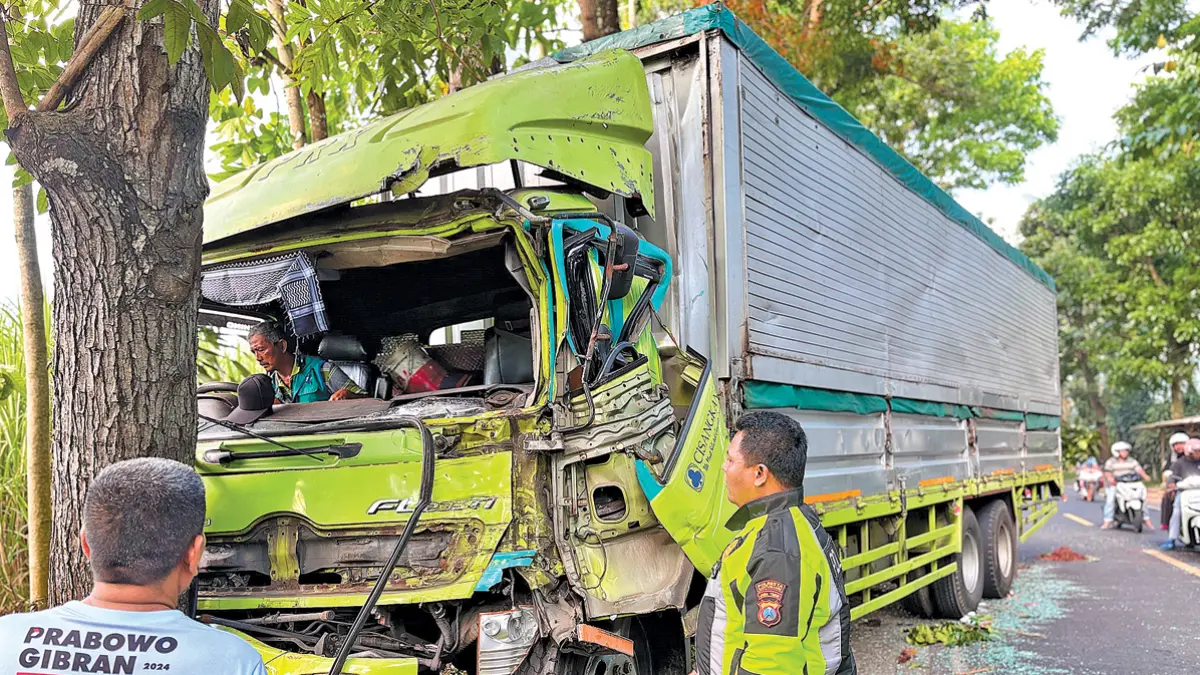 RINGSEK: Kanitlantas Polsek Kalibaru Aipda Aries Prasetyanto saat mengecek kondisi truk yang terlibat kecelakaan di Dusun Barurejo, Desa Kalibarumanis, Kecamatan Kalibaru, Jumat siang (19/6). (Aries for Radar Banyuwangi)