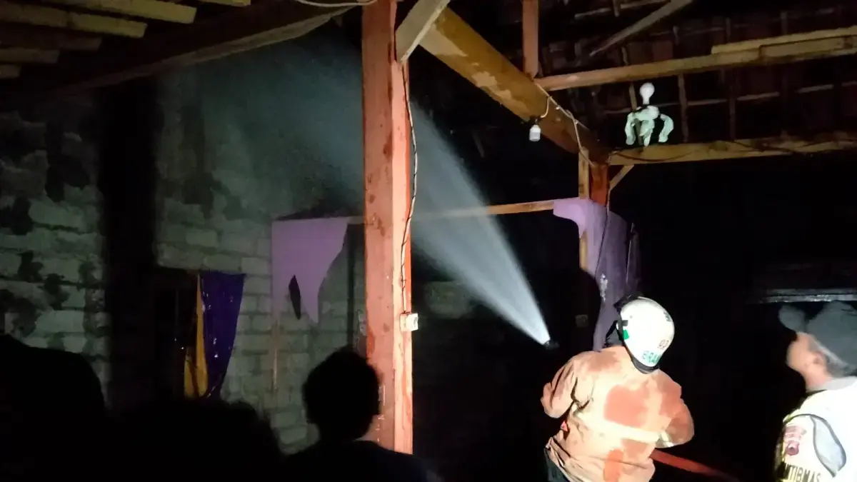 Personel Damkar Sragen padamkan api yang membakar rumah Mbah Painem di Dukuh Telon RT 39, Desa Sambi, Kecamatan Sambirejo, Kabupaten Sragen, Jumat (19/6/2026) malam. (DOK.DAMKAR SRAGEN)