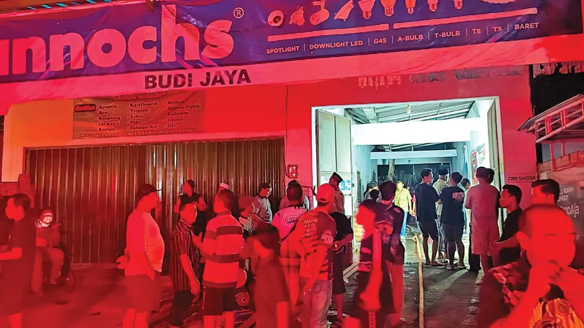 Petugas Damkarmat Sektor Srono dan Genteng serta Mako Induk memadamkan api di toko bangunan di Desa Sumbersewu, Kecamatan Muncar, yang terbakar pada Sabtu malam (20/6). (Heri Siswanto for Radar Banyuwangi)