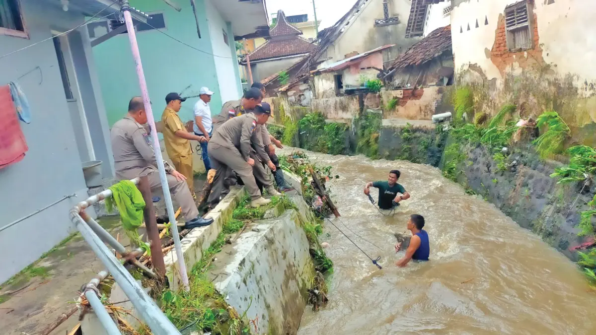 BAHU-MEMBAHU: Gabungan perwakilan Forpimka Rogojampi bersama warga mengangkat kayu yang sempat menyumbat aliran sungai di Desa/Kecamatan Rogojampi Senin (22/6). (Satrio for Radar Banyuwangi)