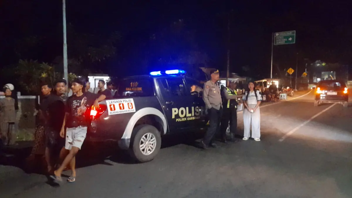Petugas mendatangi lokasi kecelakaan lalu lintas yang melibatkan sepeda motor dan truk di Jalan Raya Desa/Kecamatan Gambiran pada Sabtu malam (20/6). (Tri Pepri Alvian for Radar Banyuwangi)