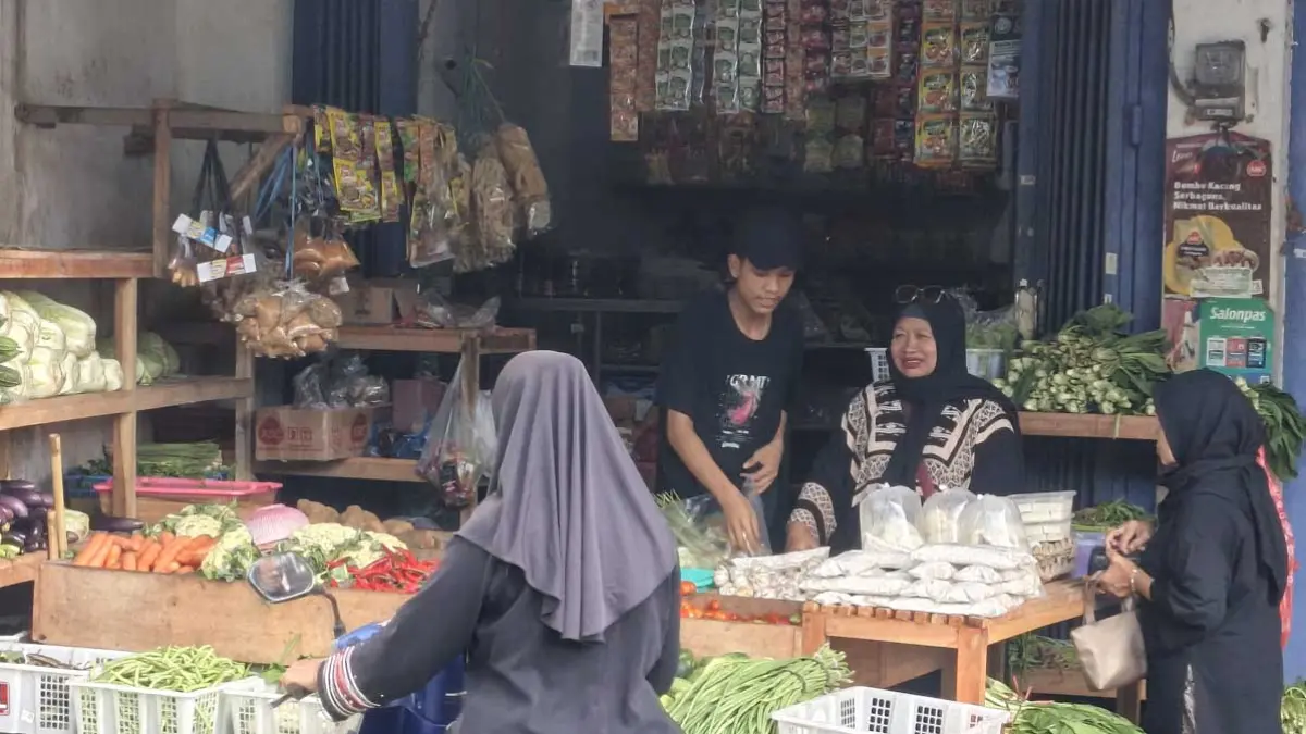 TRANSAKSI: Pedagang sembako di Pasar Blambangan sedang melayani pembeli, Senin (22/6). (Ksatria Raya/Radar Banyuwangi)