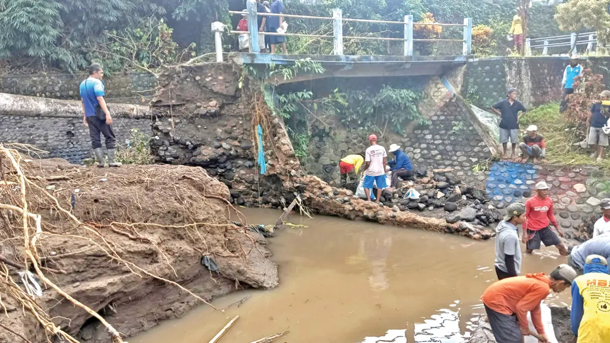 KERJA BAKTI: Para petani sekitar Dam Concrong bersama petugas pengairan Krosda Rogojampi membenahi plengsengan yang sempat jebol diterpa arus sungai, Selasa (23/6). (Jasmani for Radar Banyuwangi)