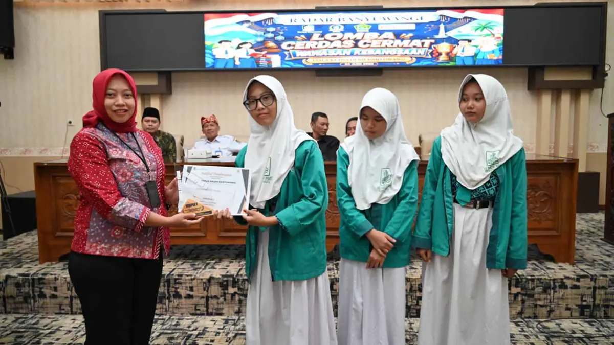 Ketua Perkumpulan Gema Pendidikan Nasional 17 Agustus 1945 (Perpenas) Banyuwangi Yunita Iliana menyerahkan piala kepada juara harapan 2 dari MTs Darun Najah Banyuwangi. (Ramada Kusuma/Radar Banyuwangi)