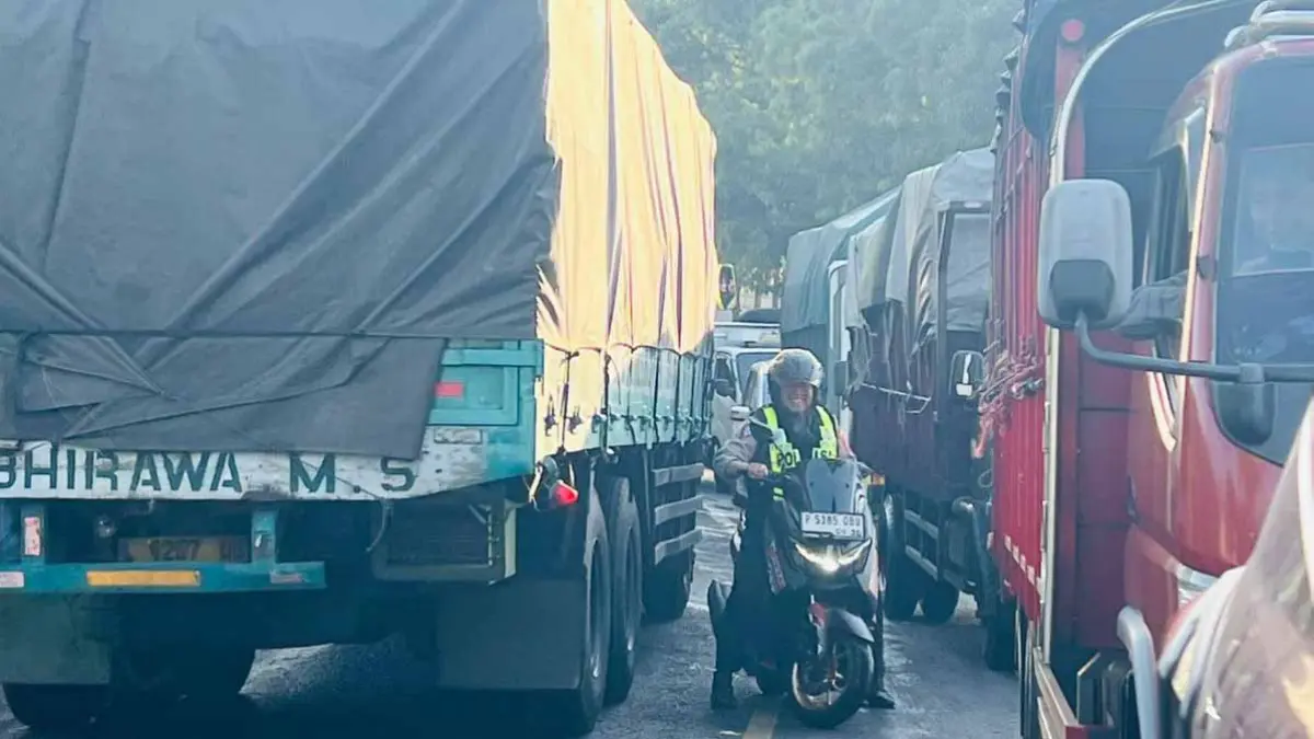 Personel Satlantas Polresta Banyuwangi menembus kemacetan truk logistik di jalur menuju Pelabuhan Ketapang, Rabu (25/6). (Bagus Rio/Radar Banyuwangi)