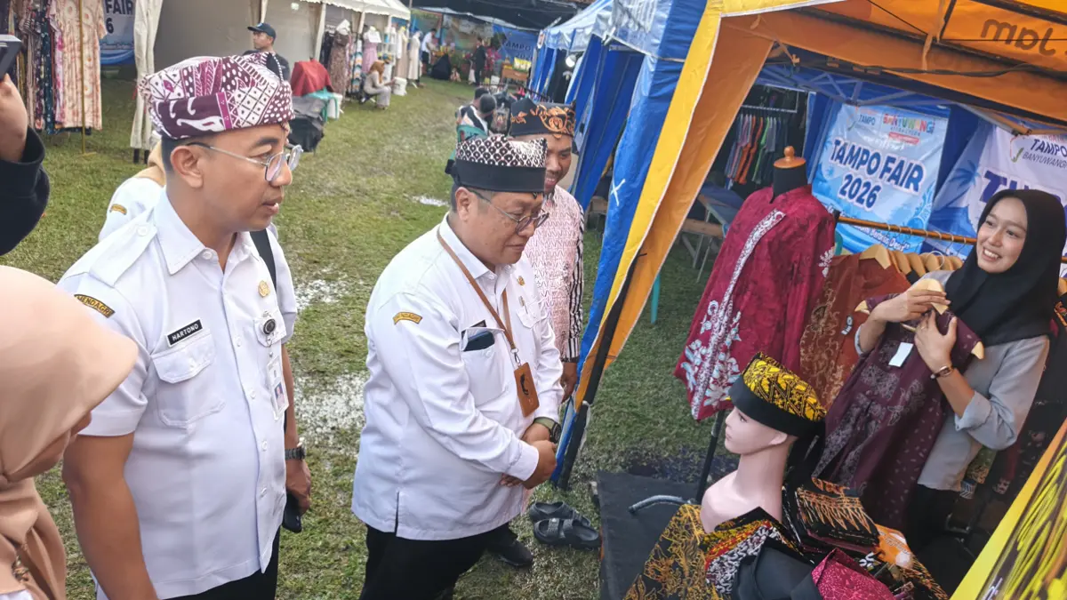 Staf Ahli Hukum dan Pemerintahan Pemkab Banyuwangi Alief Rachman Kartiono (berkacamata) didampingi Kades Tampo Hasyim Ashari (baju batik) meninjau stan UMKM di Tampo Fair, Rabu (24/6). (Zamrozi Wahyu/Radar Banyuwangi)