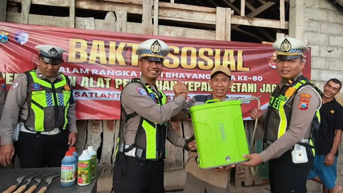 Personel Satlantas Polresta Banyuwangi menyerahkan langsung bantuan alat pertanian kepada petani di Lingkungan Watuulo, Kelurahan Bakungan, Kecamatan Glagah. (Pepri for Radar Banyuwangi)