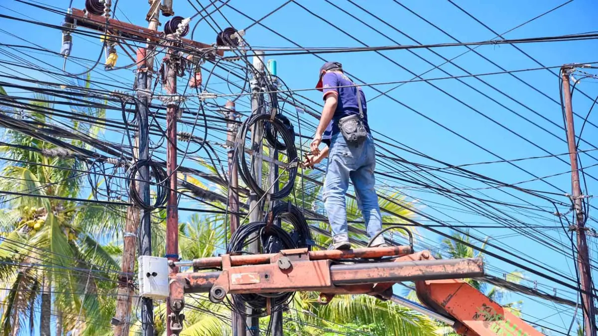Petugas PUCKPP membongkar jaringan wifi ilegal di depan gerbang Perumahan Kalipuro karena belum memenuhi kewajiban perizinan maupun pembayaran retribusi kepada pemerintah daerah. (Ramada Kusuma/Radar Banyuwangi)
