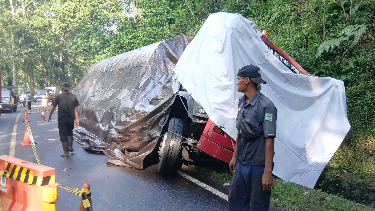 BIANG MACET: Petugas bersiap melakukan evakuasi truk tangki terperosok di selokam KM-237 masuk Dusun Barurejo, Desa Kalibarumanis, Kecamatan Kalibaru, Jumat (26/6). (Wiji for Radar Banyuwangi)