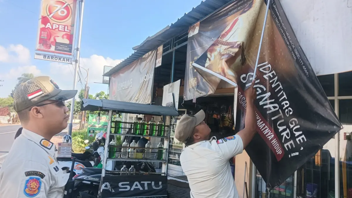 DIGULUNG: Puluhan banner di tepi jalan raya Kecamatan Muncar ditertibkan petugas pada Kamis (25/6). (Slamet Hariyadi for Radar Banyuwangi)