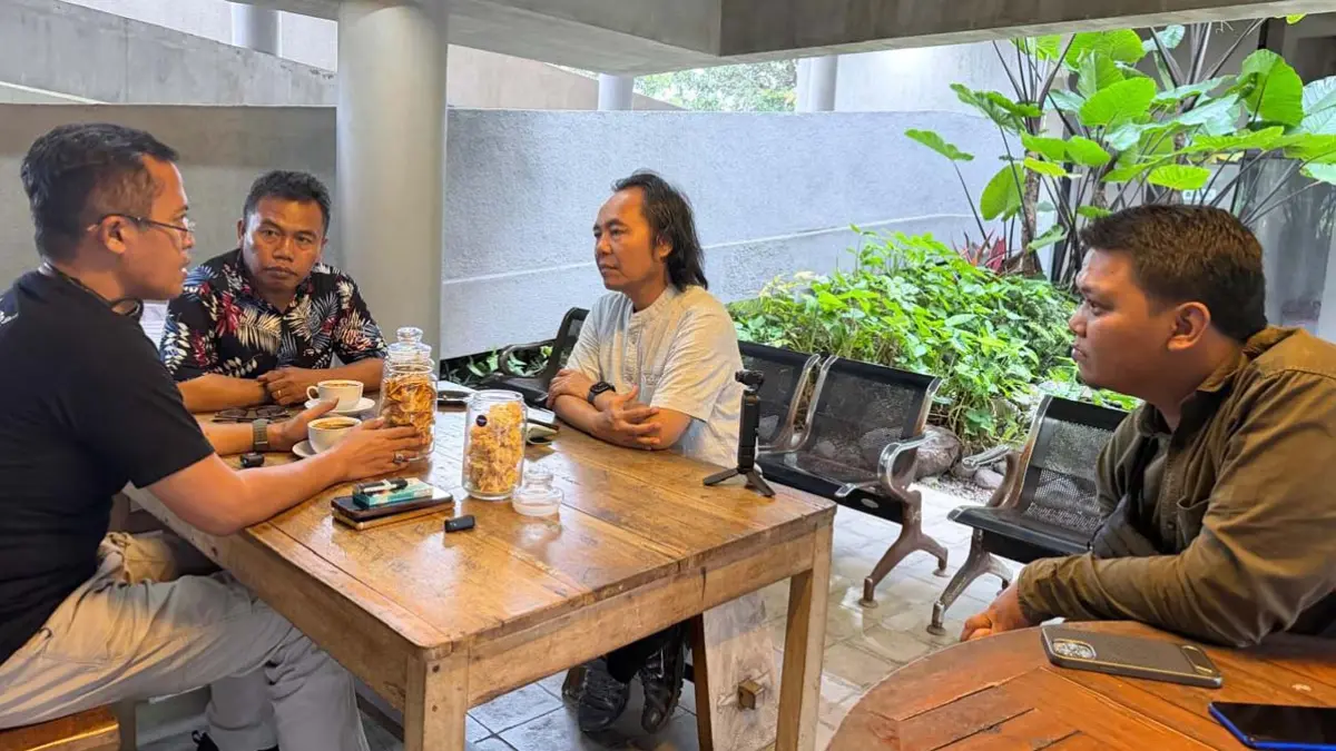 Kepala BNNK Banyuwangi Kombespol Rachmat Kurniawan berdiskusi dengan Direktur Radar Banyuwangi Samsudin Adlawi di lantai bawah gedung Grha Pena, Jumat petang (26/6). (Bayu Saputra/Radar Banyuwangi)