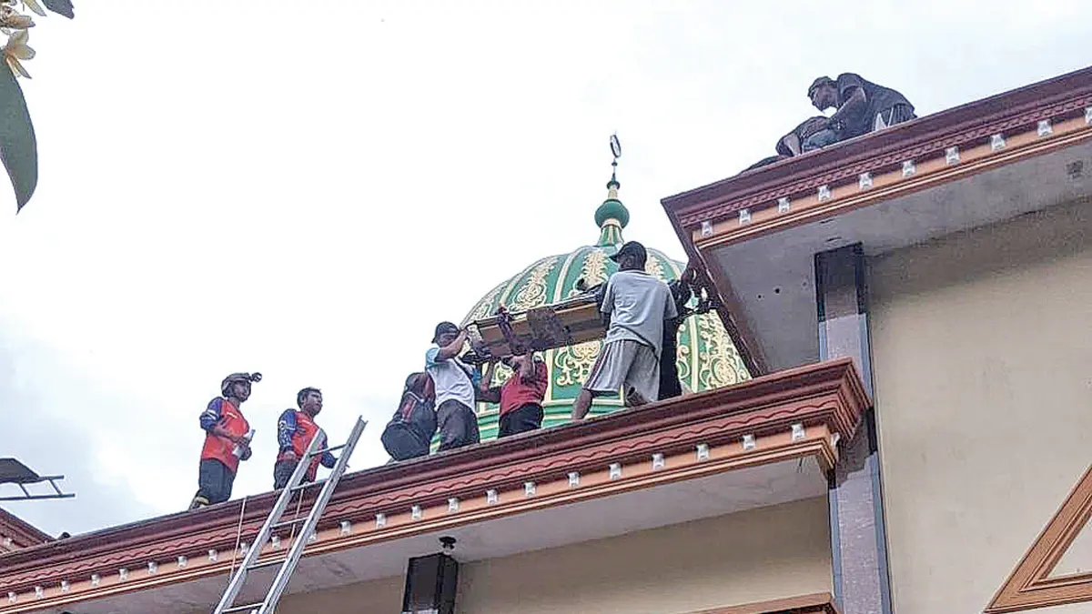 Petugas Damkarmat dibantu warga sekitar mengevakuasi Asnawi dari atap Masjid At-Taqwa di Lingkungan Porong, Kelurahan Boyolangu, Kecamatan Giri, Sabtu sore (27/6). (Damkarmat Banyuwangi)