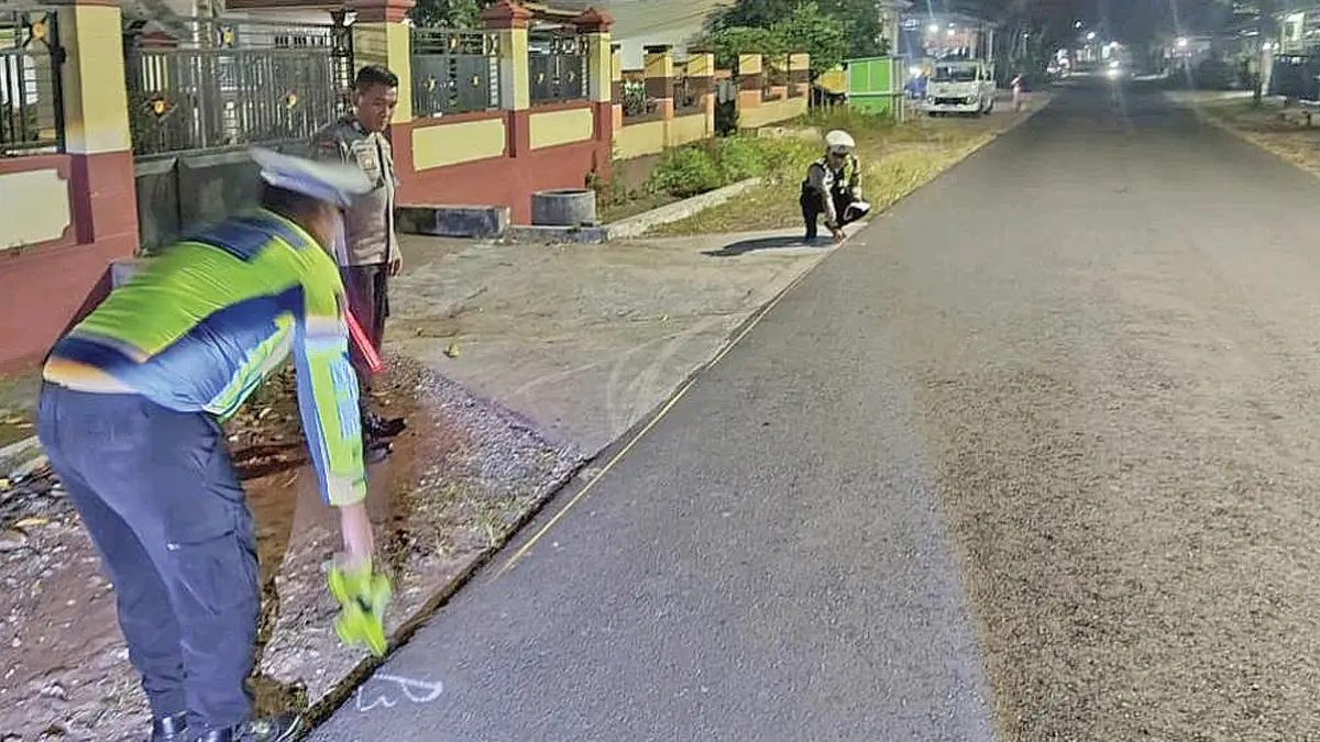 Anggota Satlantas Polresta Banyuwangi melakukan olah TKP di Jalan Raya Desa Kradenan, Kecamatan Purwoharjo, pada Sabtu malam (27/6). (Pepri for Radar Banyuwangi)