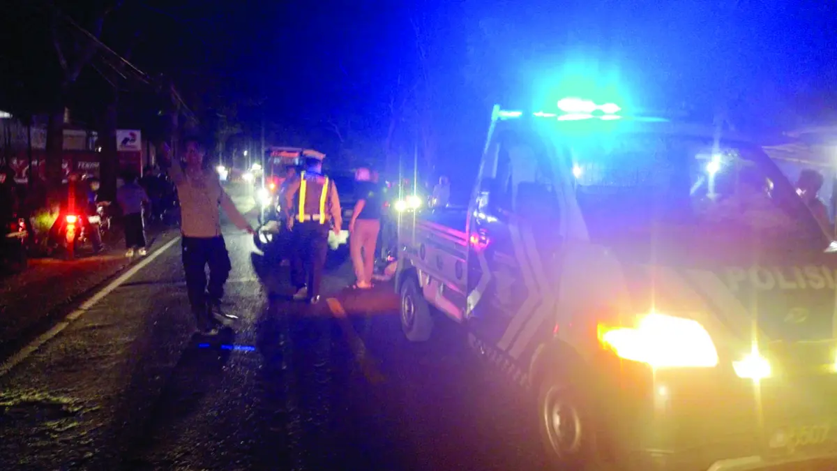 Anggota Unit Lantas Polsek Rogojampi mengatur lalu lintas pasca kecelakaan di Jalan Raya Jember, tepatnya di utara stasiun pengisian bahan bakar mini di Dusun Puspan, Desa Kedaleman, Kecamatan Rogojampi, Minggu malam (28/6). (Gatot for Radar Banyuwangi)