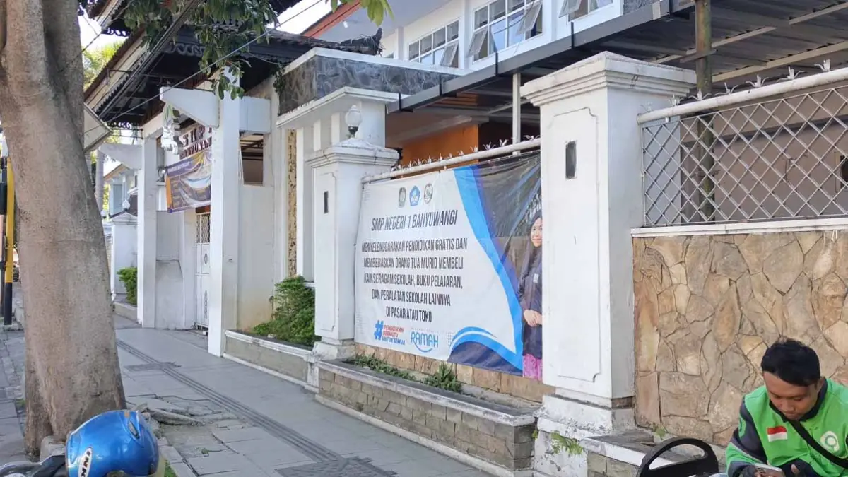 Banner yang berisi informasi pendidikan gratis terpampang di pagar SMPN 1 Banyuwangi, Senin (29/6). Ksatria Raya/Radar Banyuwangi)