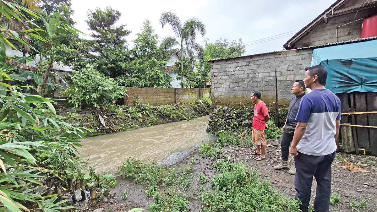 Petugas Kecamatan Sempu meninjau debit Sungai Suromenojo yang melintas di Dusun Tlogosari, Desa Jambewangi, Kecamatan Sempu. (Salis Ali/Radar Banyuwangi)