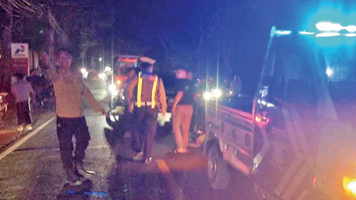 Anggota Unit Lantas Polsek Rogojampi mengatur lalu lintas usai kecelakaan yang melibatkan WNA di Jalan Raya Jember, tepatnya di utara stasiun pengisian bahan bakar mini di Dusun Puspan, Desa Kedaleman, Kecamatan Rogojampi, Minggu malam (28/6). (Gatot for Radar Banyuwangi)