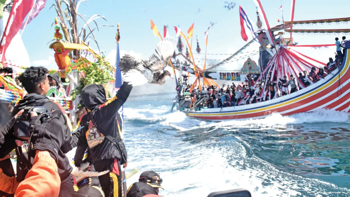 WARISAN BUDAYA: Nelayan Muncar ramai-ramai mengawal proses pengangkutan larung sesaji berupa kepala kambing dan hasil bumi sebelum dilarung di perairan Sembulungan, Rabu (1/7). (Zamrozi Wahyu/Radar Banyuwangi)
