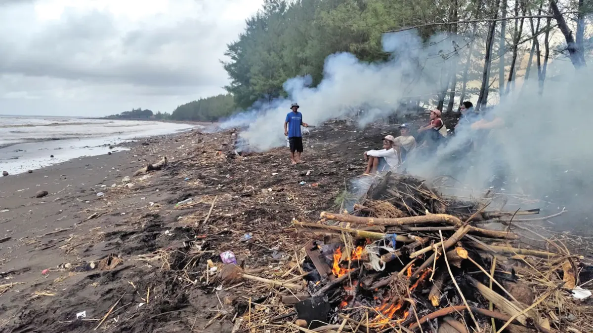 KERJA BAKTI: Anggota Pokmaswas dan warga sekitar gotong royong membersihkan sampah di Pantai Bomo pada Selasa (30/6). (Towib for Radar Banyuwangi)