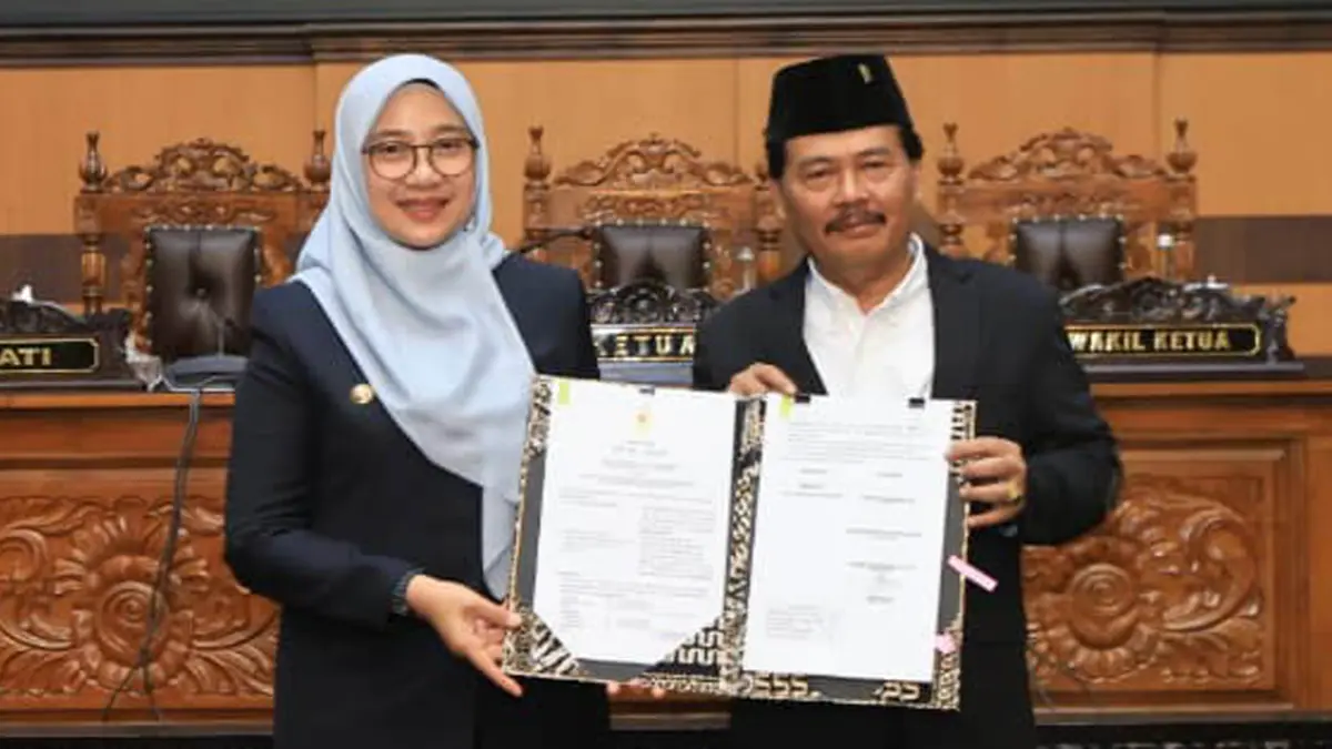 Bupati Ipuk Fiestiandani dan Wakil Ketua DPRD Ruliyono menunjukkan dokumen persetujuan bersama terhadap raperda LPj Pelaksanaan APBD 2025 di kantor DPRD Banyuwangi Jumat (3/7). (Ramada Kusuma/Radar Banyuwangi)