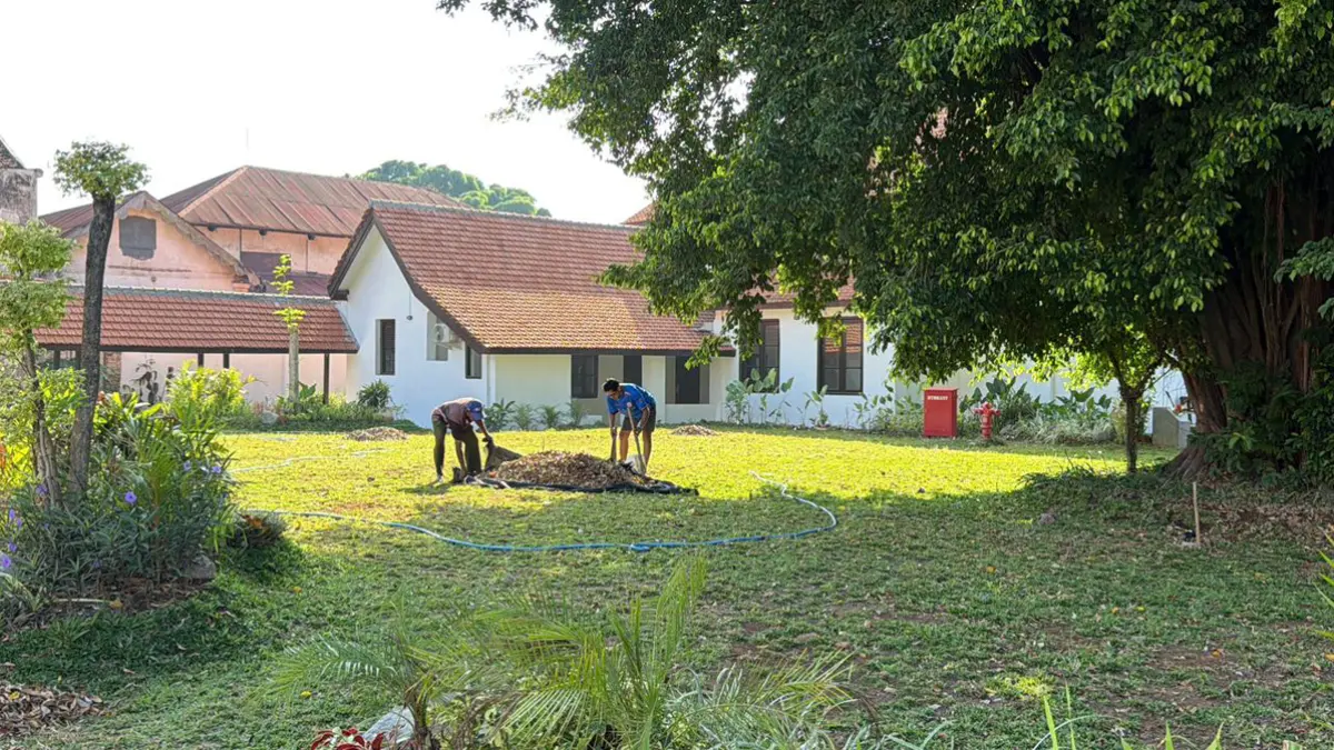 Integrasi taman dan bangunan Asrama Inggrisan setelah direvitalisasi terlihat menyejukkan, Sabtu (4/7). Pekerja memungut daun kering yang mengotori halaman Asrama Inggrisan. (Purnomo for Radar Banyuwangi)