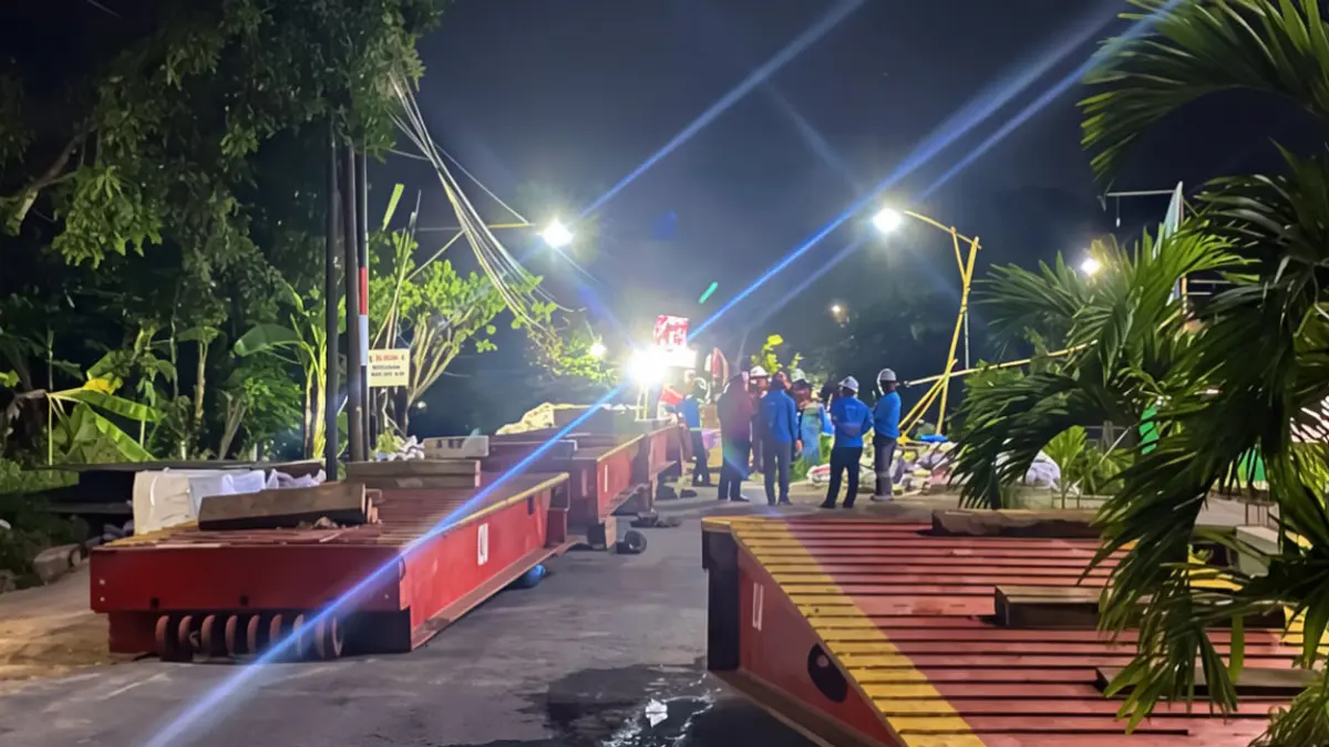 PENGUAT JEMBATAN: Sejumlah petugas GITET memasang plat besi pada jembatan yang akan dilintasi oleh trafo raksasa tadi malam (4/7) pukul 01.32. (Ksatria Raya/Radar Banyuwangi)
