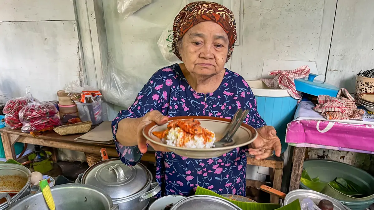 SEPORSI RP 15 RIBU: Bu Mantih menyajikan menu sego cawuk di warung miliknya tak jauh dari Terminal Rogojampi, Jumat (3/7). (Ramada Kusuma/Radar Banyuwangi)