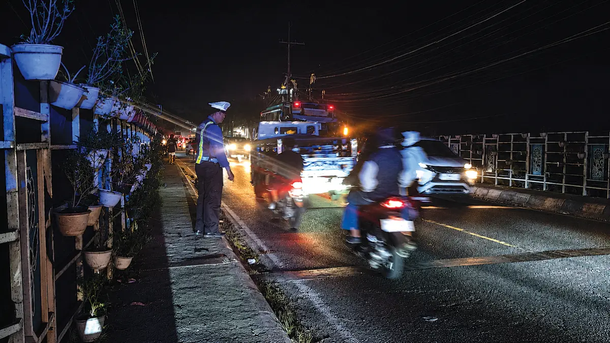 Anggota Unit Lantas Polsek Rogojampi memeriksa lokasi laka lantas di jembatan jalan raya Dusun Lugonto, Desa/Kecamatan Rogojampi, pada Sabtu malam (4/7). (Gatot for Radar Banyuwangi)