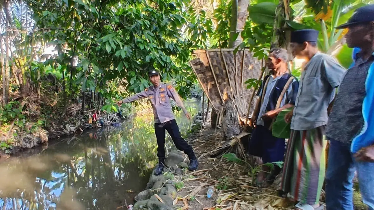 Anggota Polsek Singojuruh melakukan pemeriksaan di lokasi ditemukannya lansia yang meninggal di sungai Dusun Pasinan, Desa/Kecamatan Singojuruh, Senin (6/7). (Achmad Rudy for Radar Banyuwangi)