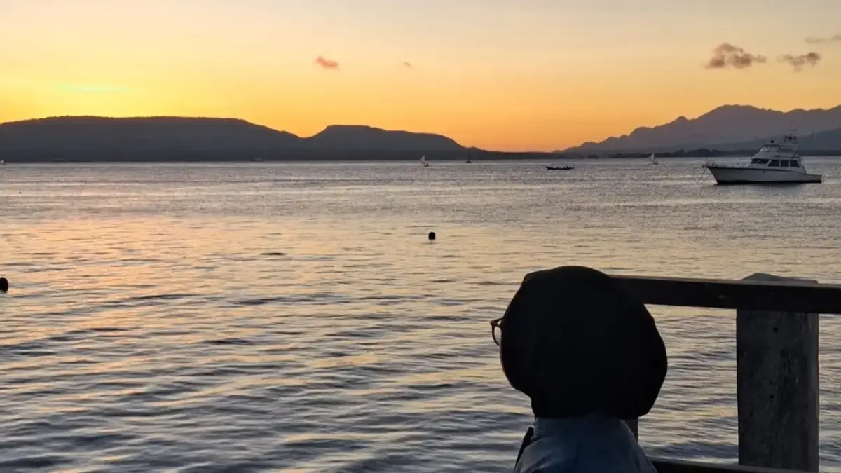 Pengunjung menikmati panorama matahari terbit di Pantai Dermaga Cinta, Kelurahan Bulusan, Kecamatan Kalipuro, Senin (6/7). (Mayang Dwi for Radar Banyuwangi)