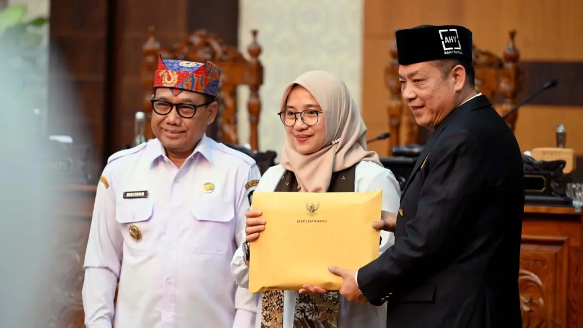 Bupati Ipuk Fiestiandani didampingi Wabup Mujiono menyerahkan dokumen rancangan KUA-PPAS kepada Wakil Ketua DPRD Michael Edy Hariyanto pada forum rapat paripurna di kantor dewan, Rabu (8/7). (Ramada Kusuma/Radar Banyuwangi)